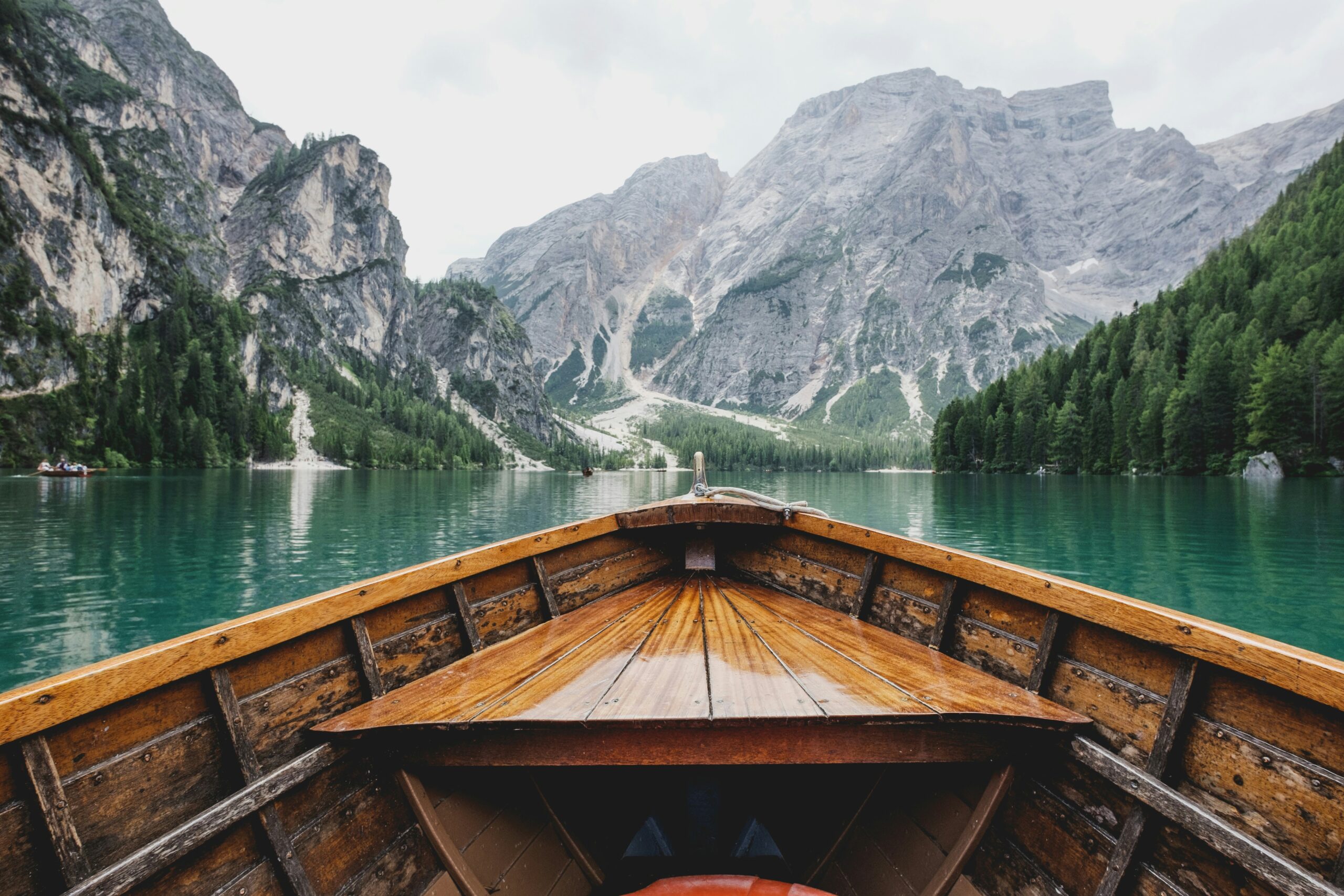 Somatic therapy in Maryland and Virginia concept image of a wooden boat moving across a calm mountain lake, symbolizing nervous system regulation and emotional resilience.